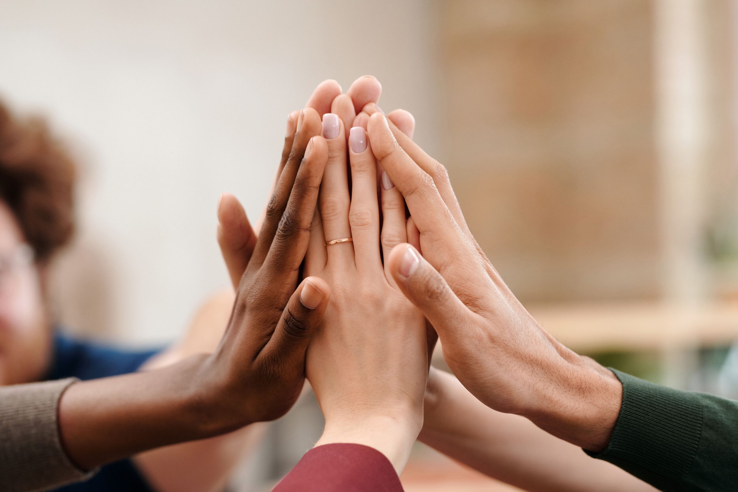 Group of TTC women putting their hands together in support