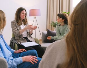 Women sitting together in a TTC support group discussing their infertility journey.